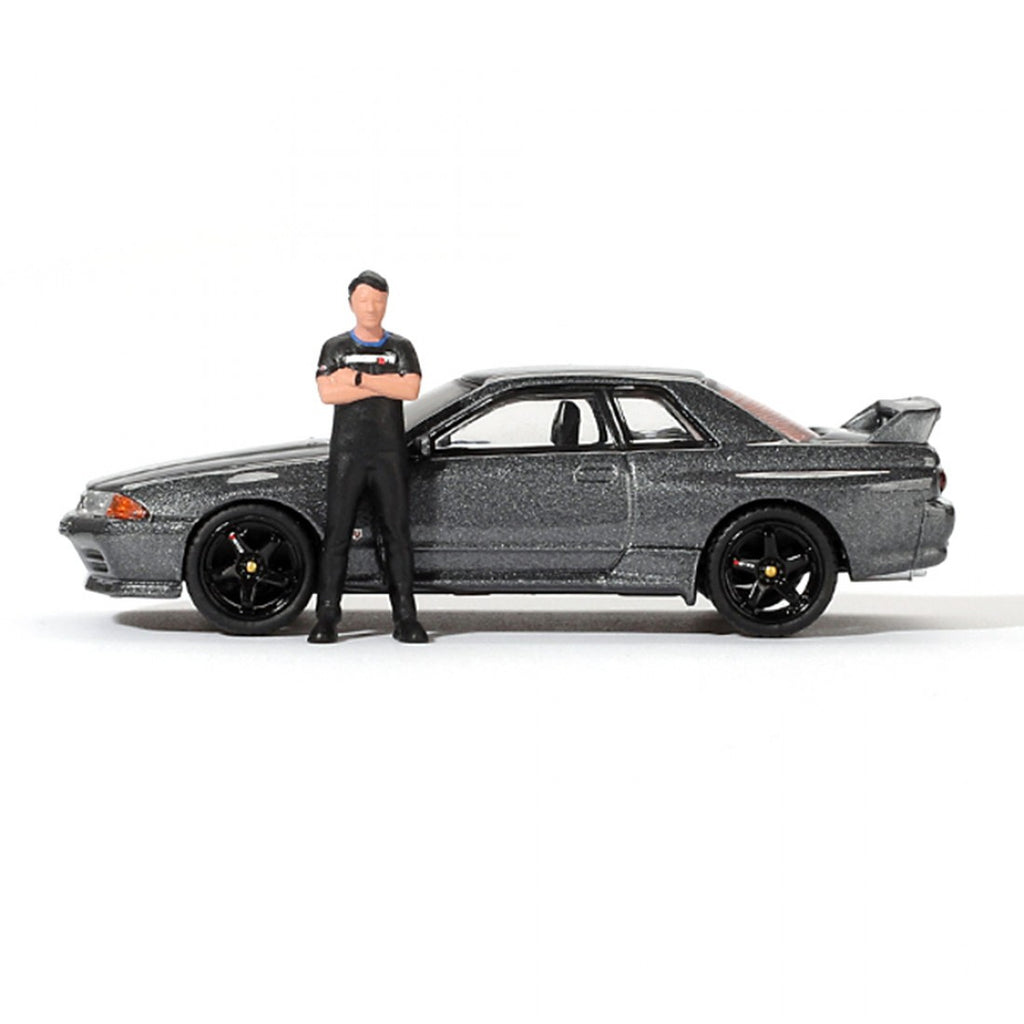 Mini GT 1:64 Nissan Skyline GT-R (R32) Nismo Gunmetal con figura de Matsuda – Colección Tsugio Matsuda PRESENTACIÓN EN CAJA
