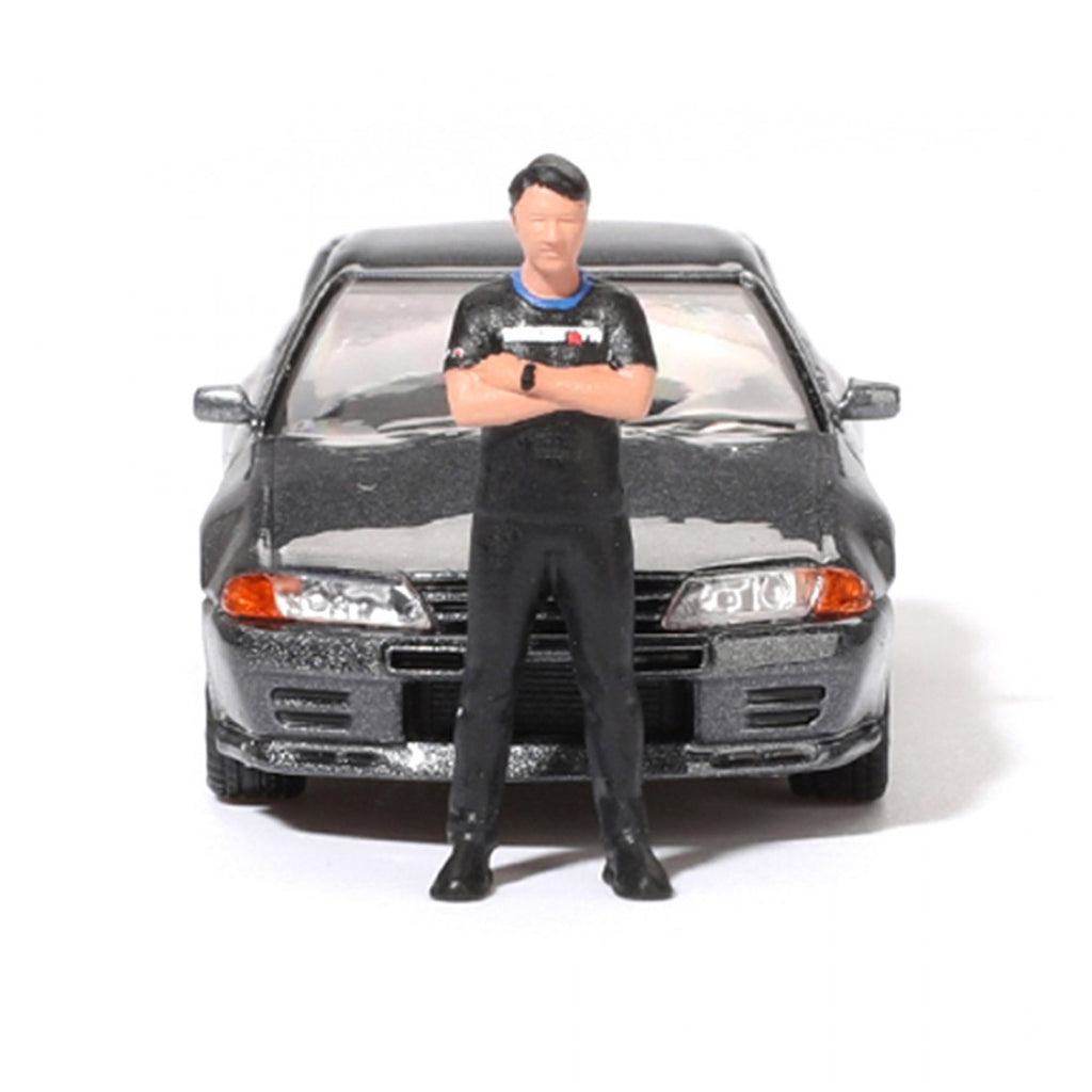 Mini GT 1:64 Nissan Skyline GT-R (R32) Nismo Gunmetal con figura de Matsuda – Colección Tsugio Matsuda PRESENTACIÓN EN CAJA